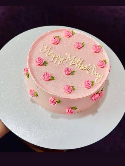 A larger Mother's Day cake with pink frosting and a pattern of delicate piped roses. This is a great option for a bigger family celebration.