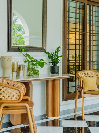 This elegant console setup combines a marble-top table with a fluted wooden base and classic cane chairs. It's a perfect example of how I mix textures and materials to create a sophisticated entryway or hallway feature.