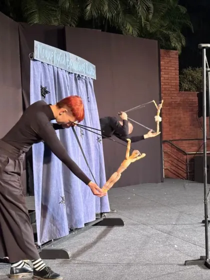 Two puppeteers work in perfect sync to operate a single marionette in 'Theatre in the Pocket'. This demonstrates the incredible skill and coordination required for advanced marionette theatre.