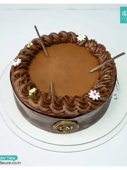Our signature Chocolate Truffle Cake. It features a rich, dark chocolate glaze, a border of silky truffle piping, and delicate chocolate stick accents.