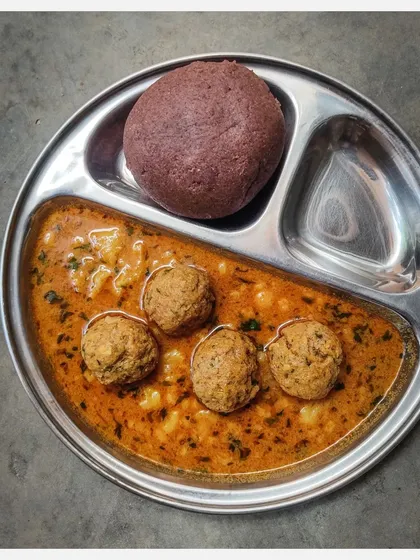 A traditional steel plate serving of my Khaima Unde Saaru with Ragi Mudde.