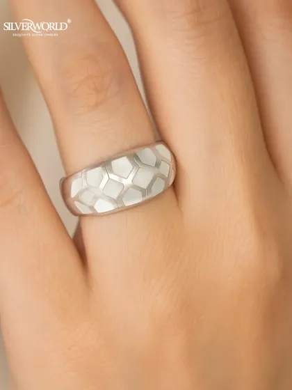 This modern honeycomb silver ring features a unique geometric pattern with white enamel inlay. Its wide band and bold design make it a contemporary statement piece.