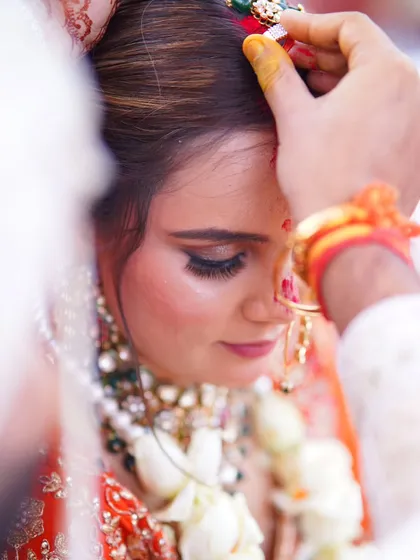 The sindoor daan is one of the most powerful moments in a Hindu wedding. This close-up shot focuses on the emotion and significance of the ritual, a memory that is truly priceless.