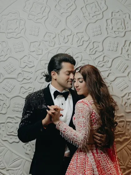 A romantic dance, captured against an intricate, textured backdrop. This shot highlights the couple's graceful movement and close connection, creating a timeless and elegant portrait.