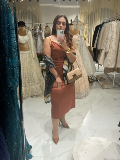 A mirror selfie showcasing a look for a day of shopping and client meetings. I styled this rust-colored shift dress with a printed scarf and neutral accessories for a polished yet comfortable outfit.