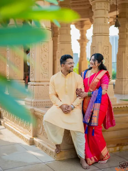 A stunning portrait of Jagruti and Shubham at a temple-like location. The architectural details of the pillars add a sense of grandeur and tradition to the photo.