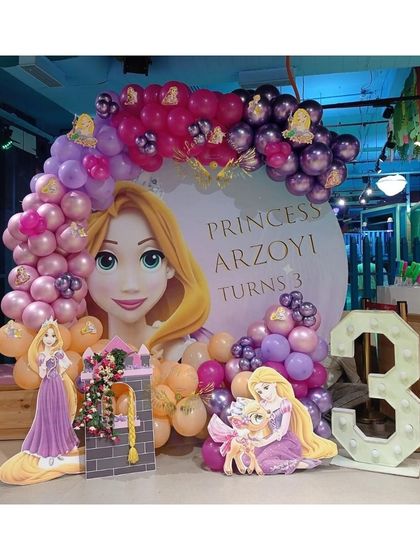 A Rapunzel (Tangled) theme for a third birthday, with a custom backdrop, character cutouts, and a marquee number '3'.