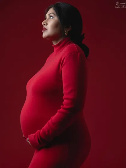 A bold and powerful statement. A simple, form-fitting red dress against a matching red background creates a stunning monochrome color portrait.