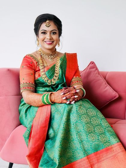 A full-length view of this classic South Indian bridal look. The makeup, hair, and styling all come together to create a picture-perfect image.