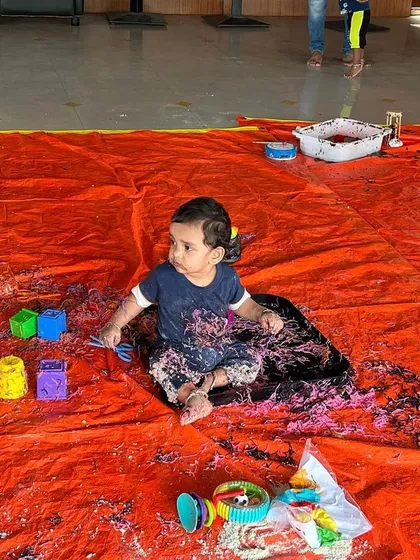 This baby is fully immersed in a tray of colorful, taste-safe noodles. For this age group, I ensure all materials are safe if they end up in the mouth, so they can explore without worry.