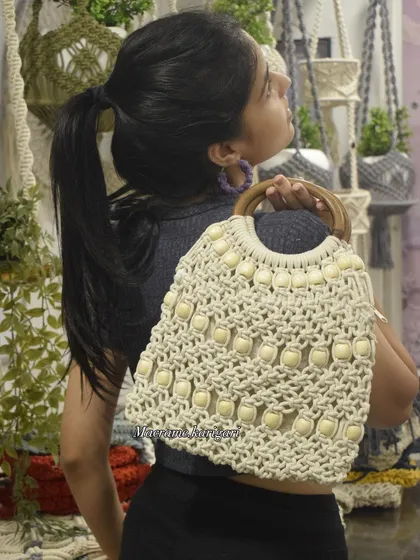 Modeling our beaded macramé tote to show how it looks when carried. It's a versatile piece that adds a touch of handmade elegance to any outfit.
