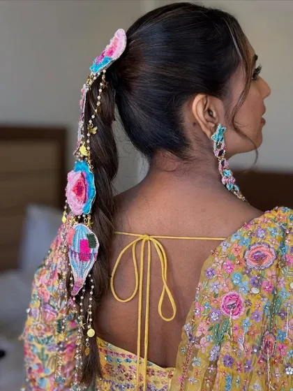 A side view of the carnival-themed braid, showing how the quirky accessories are attached along the length of the hair. This is a great example of a customized, high-fashion hairstyle.