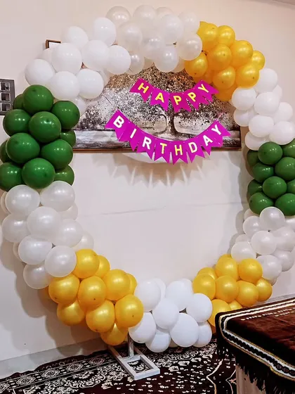 A circular balloon ring in the colors of the Indian flag for a patriotic-themed birthday. A simple 'Happy Birthday' banner is strung across the center of the ring.