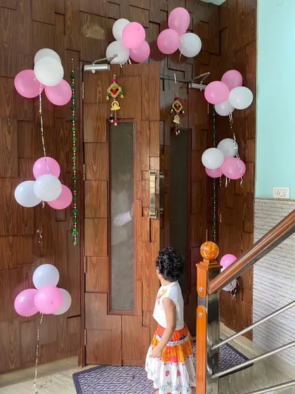 Even a simple door decoration can make the welcome feel special. Here, I've used bunches of pink and white balloons to frame the main entrance, creating a sweet and simple welcome home surprise.