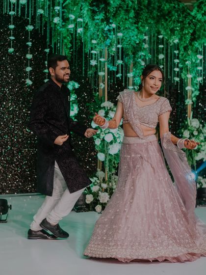 A candid shot of the couple dancing together on stage, their smiles showing the pure fun they're having.