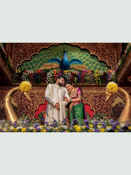 The couple shares a tender moment in front of the ornate peacock stage, a beautiful memory of their engagement.