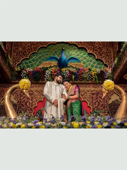 The couple shares a tender moment in front of the ornate peacock stage, a beautiful memory of their engagement.