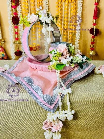 A closer look at our popular pink and silver Karvachauth thali. The intricate silver lace border and delicate floral arrangement with pearl hangings make this a truly elegant and sought after design.
