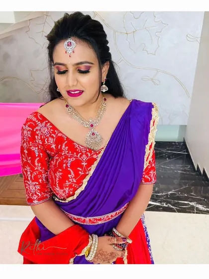 Our client looking radiant in her custom red and purple half-saree, perfectly accessorized for a special occasion.