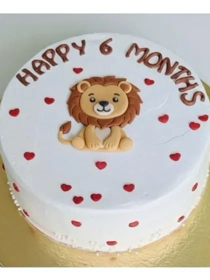 A simple and sweet half-birthday cake featuring a cute lion. This eggless chocolate strawberry cake is covered in fresh whipping cream and decorated with little red hearts.
