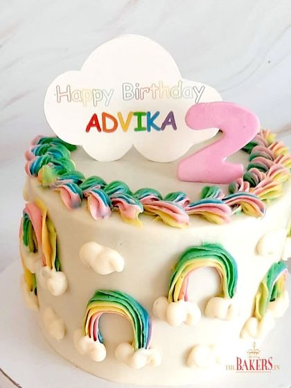 A bright and cheerful no-fondant rainbow theme cake for Advika's 2nd birthday. The design, provided by the client, uses colorful buttercream piping to create cute little rainbows all around the cake.