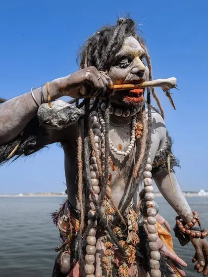 An Aghori sadhu during the Masaan Holi rituals in Banaras, a festival that confronts life and death. This image captures the raw, untamed energy of the ceremony against the backdrop of the holy Ganges river.
