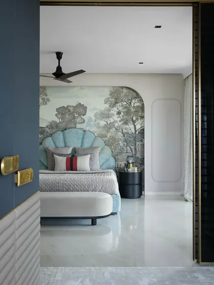 The daughter's bedroom in the same South Bombay home is both bold and stylish. A statement shell-shaped headboard in light blue is set against a beautiful custom wallpaper, creating a whimsical and personal space.