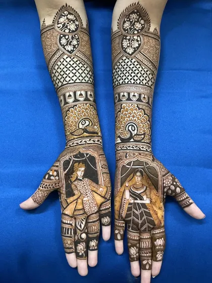 A classic bride and groom portrait design, showcasing the rich, dark stain from my natural henna. The figures are framed beautifully, with detailed jaali work and peacock motifs extending up the forearms.