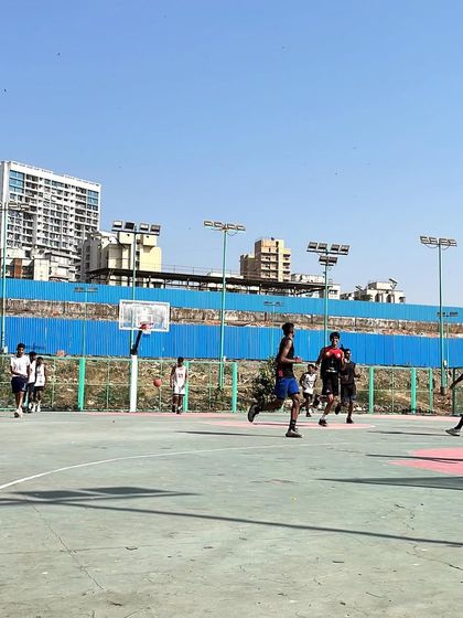 A wide shot of our team playing during the Navrang Fest. The open court and clear skies were the perfect setting for a day of competitive basketball.