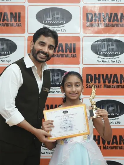 A teacher presents an award to a smiling student, recognizing her progress in painting.