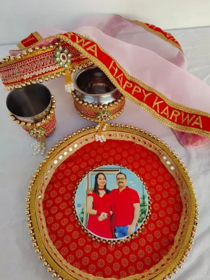 I create bespoke Karwa Chauth pooja sets like this one. This traditional red and gold set is fully personalized with a couple's photo on the thali, and matching designs on the chhalni (sieve), lota (water pot), and glass.