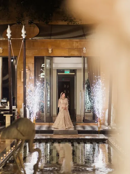 The bride's entrance is a pivotal moment, and I ensure it is as grand as she deserves. This dramatic entrance, framed by water features and cold sparklers, was designed to be a breathtaking start to the festivities.