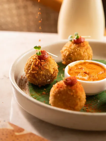 A dusting of spice over crispy appetizer balls, adding a final layer of flavor and visual texture.