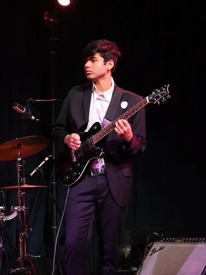 An electric guitarist ready for his solo. We teach various styles, from rock to jazz, ensuring our guitar students are versatile performers.