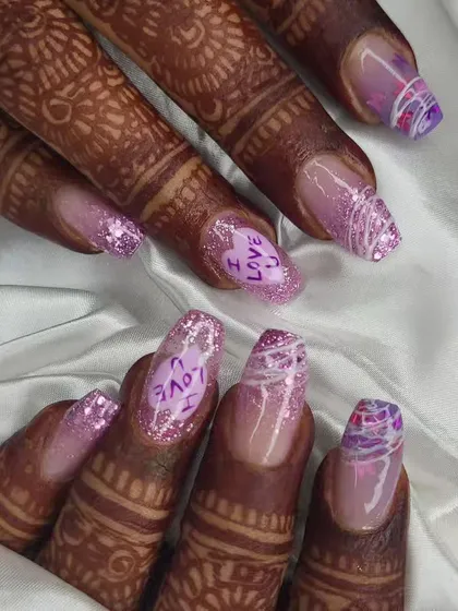 A closer look at the details on this custom bridal set. The combination of glitter, hand-lettering, and abstract designs makes for a truly personal and memorable manicure for the big day.