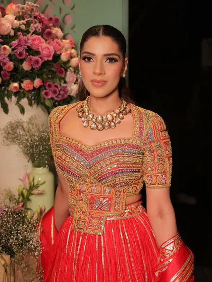 A close-up portrait highlighting the flawless makeup and the intricate, colorful embroidery of the outfit.