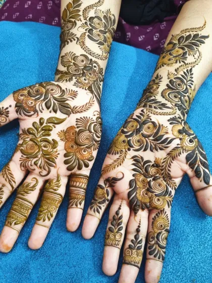I love the grace of a beautiful Arabic henna design. This style features bold floral and vine motifs that flow elegantly across the hands, leaving some open skin for a striking contrast. It's a perfect choice for a sophisticated party look.