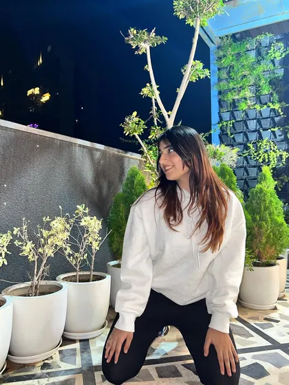 A happy, kneeling pose in the white hoodie. This shows a playful and relaxed moment.