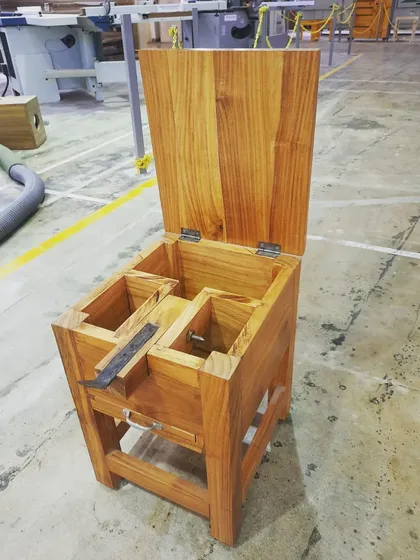 The coconut grater shown with its lid open, revealing the internal compartments and the mounted grating tool.