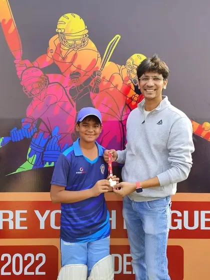Aditya Balaine receiving the best batter award from a proud parent.