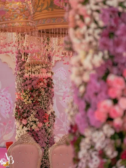 A close-up of the breathtaking floral columns of a pastel-themed mandap at Raffles Udaipur. The intricate layering of blush, lilac, and ivory flowers against a custom-printed backdrop created a whimsical, garden-like feel.