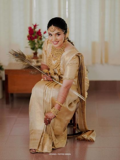 An elegant portrait of the bride seated with a peacock feather, a symbol of grace and beauty.