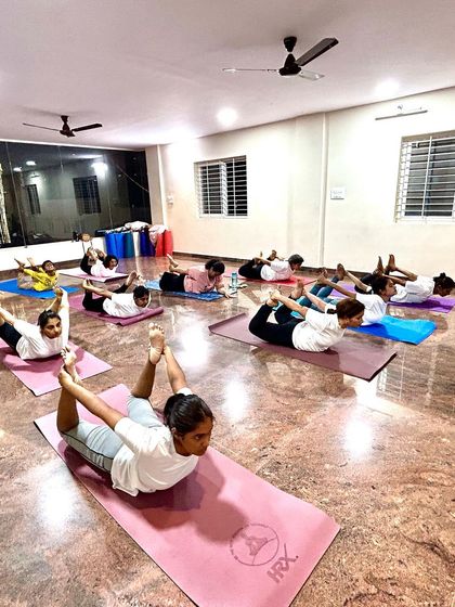 A class fully engaged in the Bow Pose. This posture strengthens the entire back of the body and provides a wonderful stretch to the front.