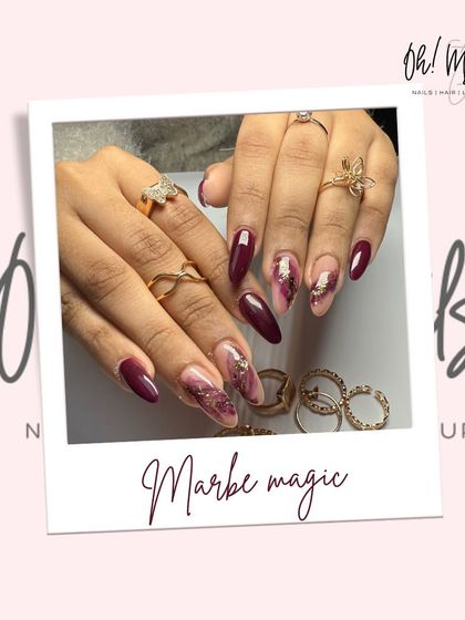 Nailed it with marble magic. This sophisticated design features a deep maroon base with accent nails showcasing a beautiful marble effect with gold foil details.