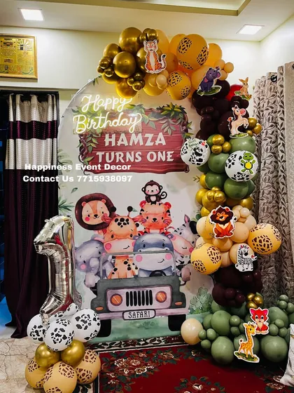 A first birthday is a special milestone, and my jungle safari theme is a client favorite. This home decor setup includes a custom backdrop with cute animals, a balloon garland in jungle colors, and a foil number '1' balloon.