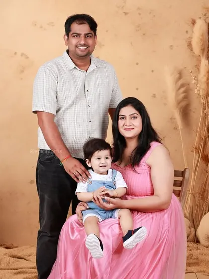 A warm family portrait against an earthy, bohemian-style backdrop. The soft tones and textures create a cozy and inviting atmosphere.