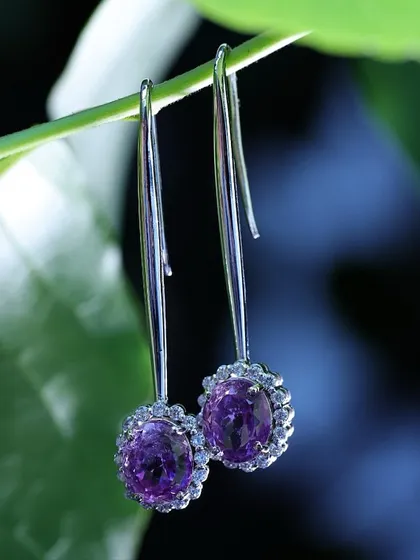 A simple green stem acts as a natural display for these drop earrings, creating a fresh and delicate look that emphasizes the product's elegant design.