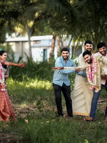 Weddings are about fun and family. We captured this playful 'tug-of-war' between the bridesmaids and groomsmen, a candid moment that shows the joy and friendly banter of the wedding day in Palladam.