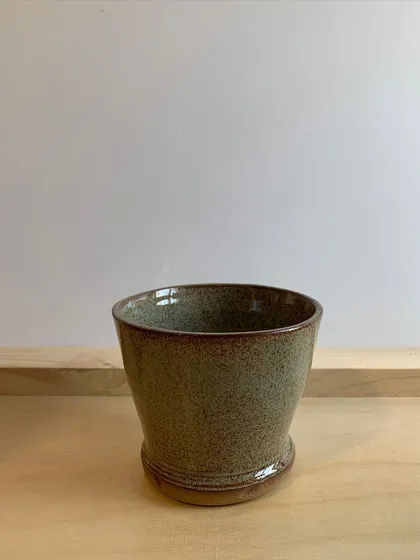 A simple, elegant pot with a speckled glaze. This piece was beautifully thrown on the wheel by a student.