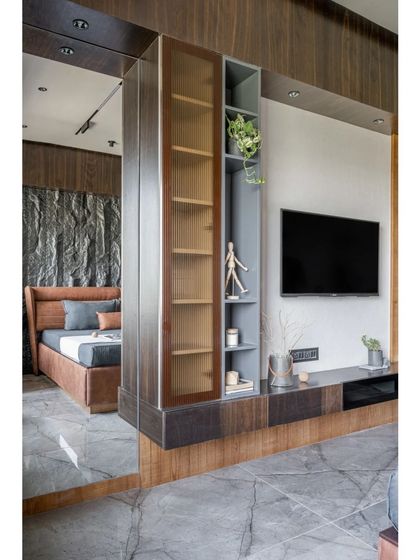 This image shows an innovative storage solution I designed to cleverly partition space. A mirrored surface reflects the bedroom, making the corridor feel wider, while the integrated shelving provides functional display and storage.